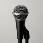 Close-up of a microphone on a stand against a neutral background