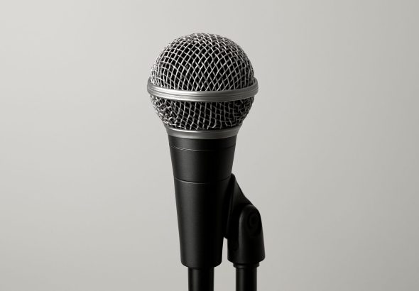 Close-up of a microphone on a stand against a neutral background